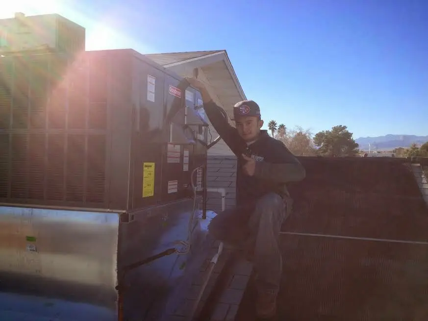 HVAC technician performing Air Duct Cleaning on a rooftop unit in Tuckahoe